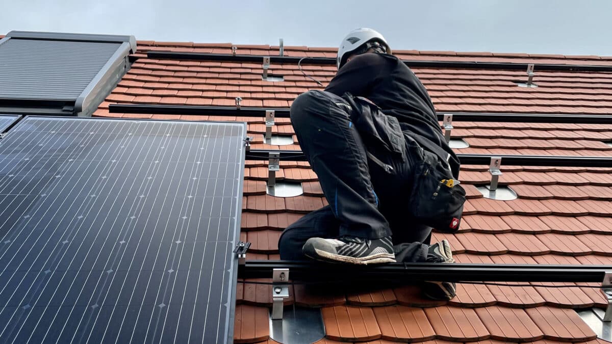 installateur op het dak met zonnepanelen