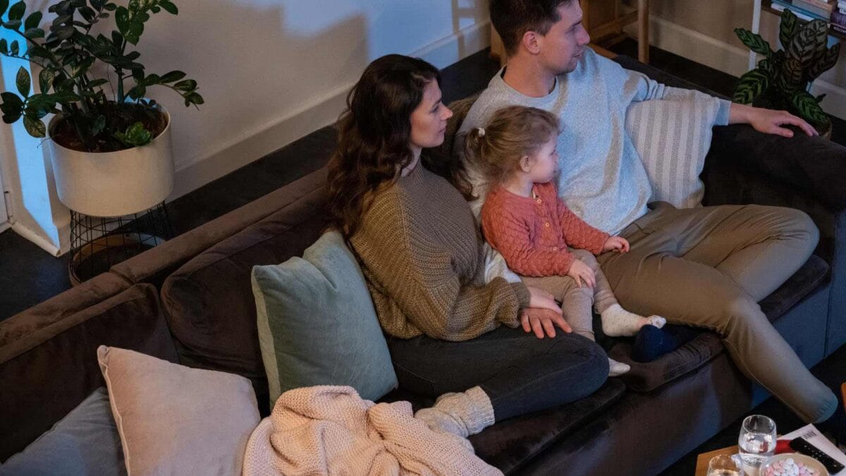 Gezin op de bank in het donker met kaarsen aan